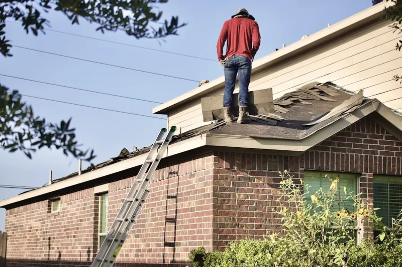 Professional roofer working on a residential roof in North Broadway - Holiday